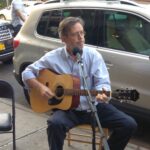 A man playing a guitar while singing