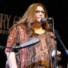 A woman wearing specs speaking on the microphone